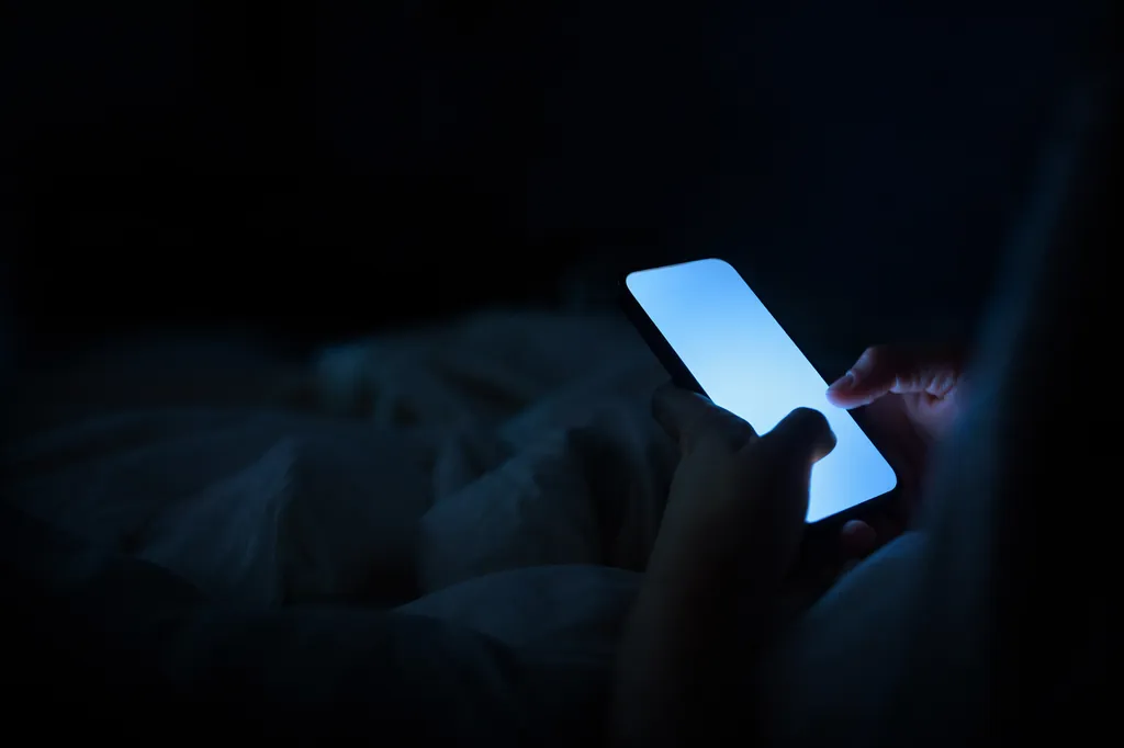 Teléfono iluminado en la oscuridad del cuarto